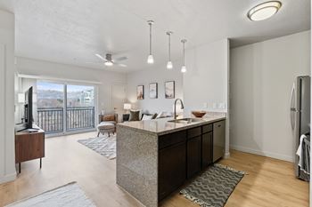 A modern kitchen with a large island and a view of the city.